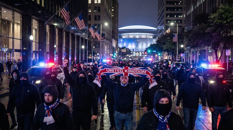 Vermummte britische Fußballfans marschieren nachts durch eine US-Stadt mit Polizeieskorte vor der WM 2026
